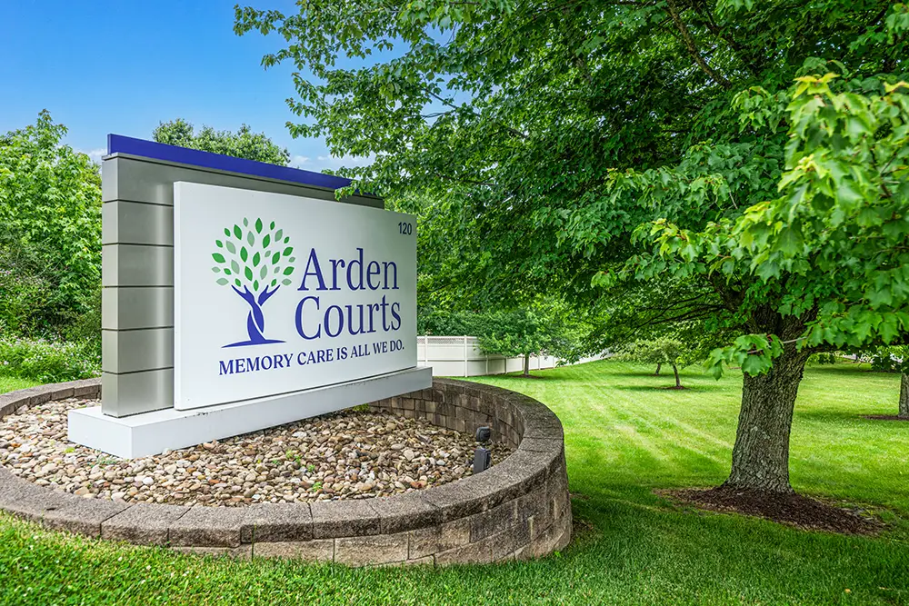 Monroeville-14 A large outdoor sign reads “Arden Courts: Memory care is all we do,” surrounded by grass, trees, and landscaping rocks.
