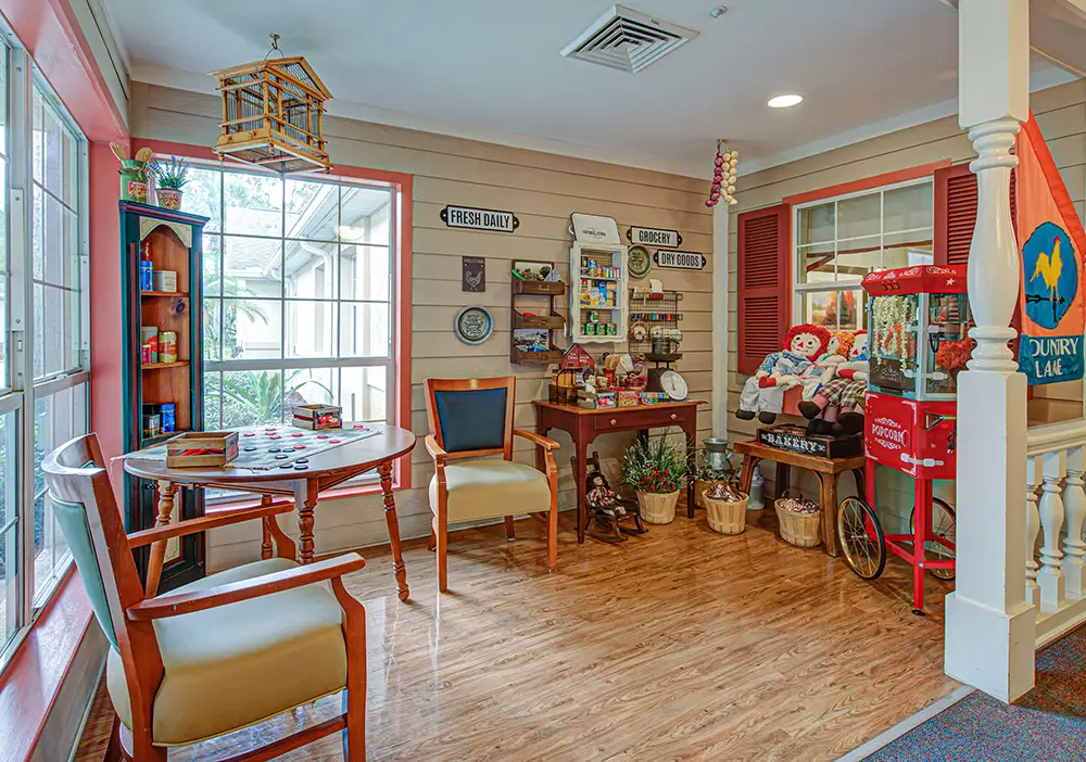 A cozy corner features a round table with chairs, shelves of vintage items, a popcorn machine, and decorative touches resembling an old-fashioned general store. A cozy corner features a round table with chairs, shelves of vintage items, a popcorn machine, and decorative touches resembling an old-fashioned general store.