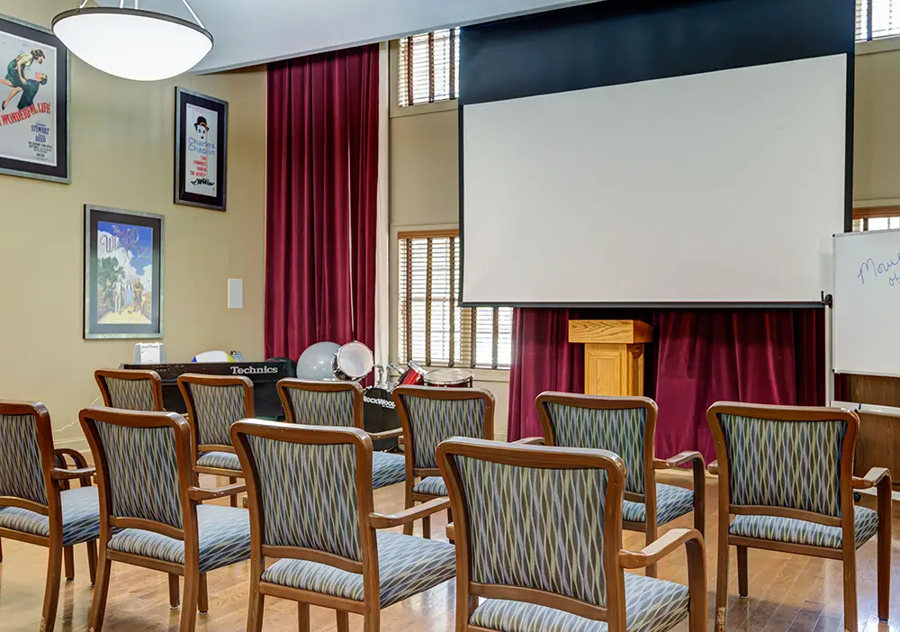 A room with chairs and a projector screen. A room with chairs and a projector screen.
